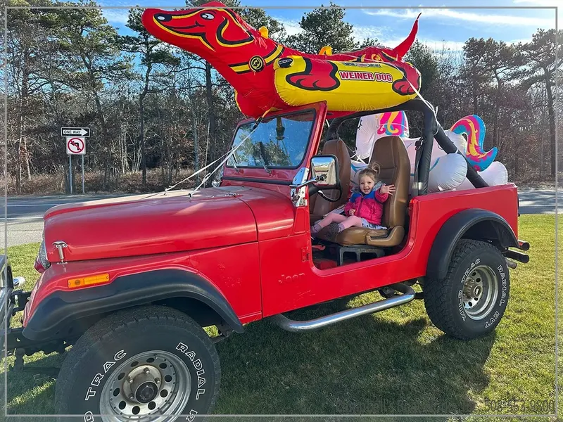 Red Jeep decked out with inflatable toys