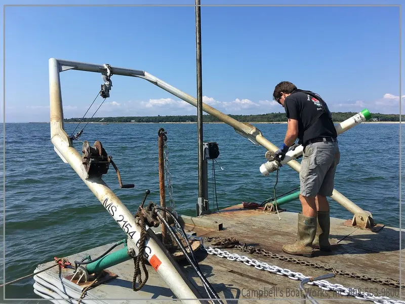Crew member working on a mooring from a service barge