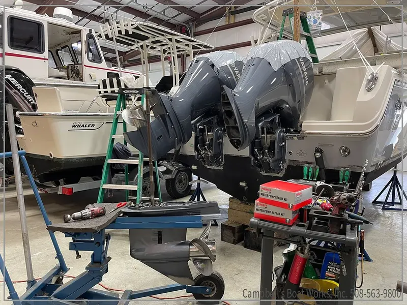 Technician servicing twin Yamaha outboards in the shop