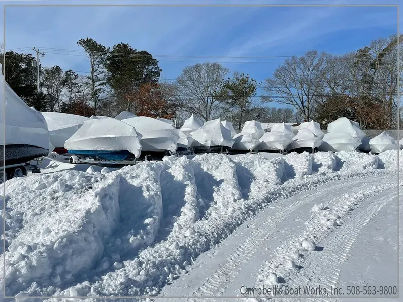 Boats stored in the yard under winter snow